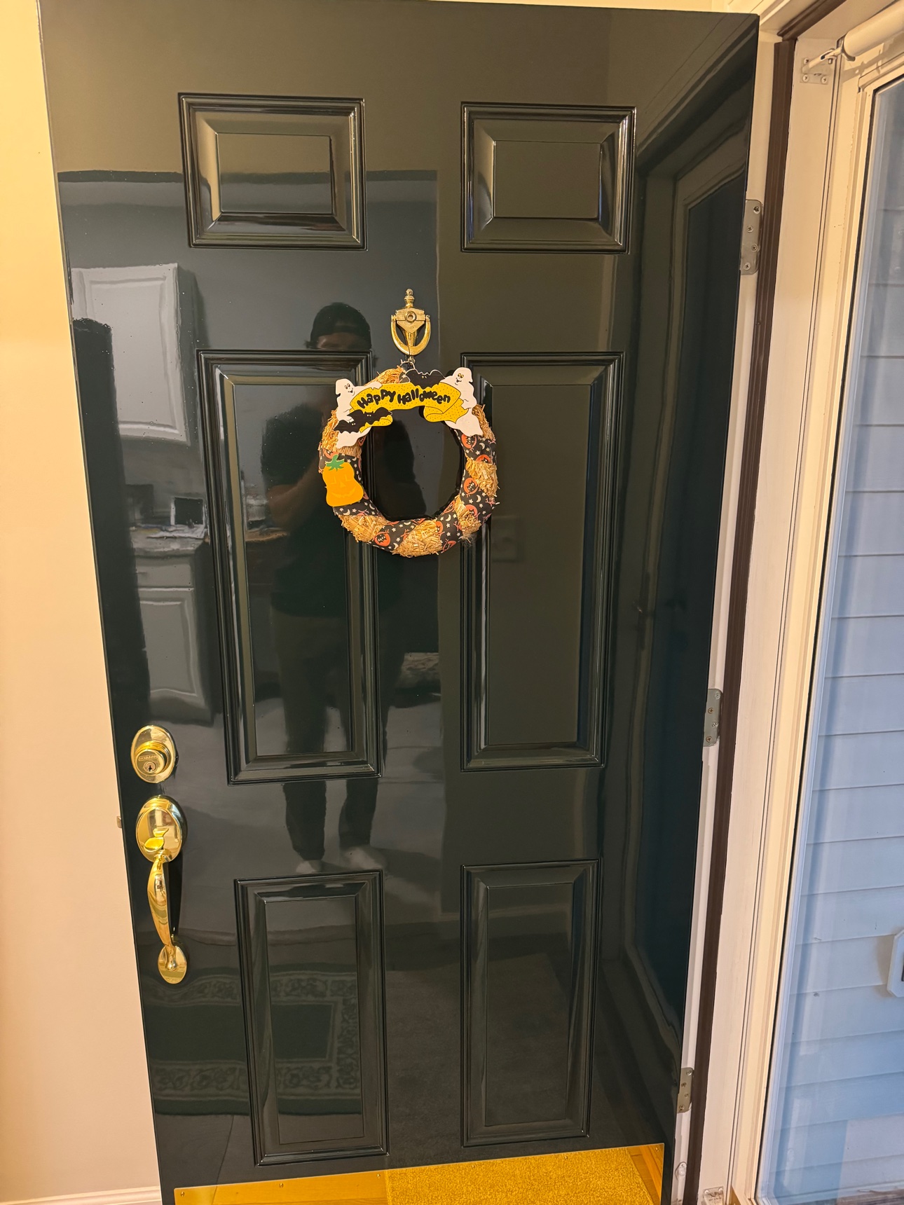 Entry door refinished in black high gloss, exterior face, with polished brass door knocker and kick plate