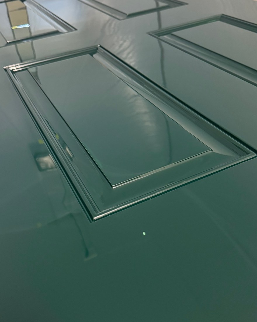 Detail of one raised panel on the door in the booth, the gloss reflecting across its surface